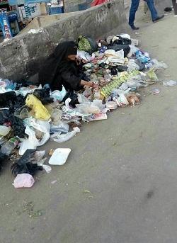 صورة صادمة لإمرأة يمنية تبحث عن طعام في كوم للقمامة 