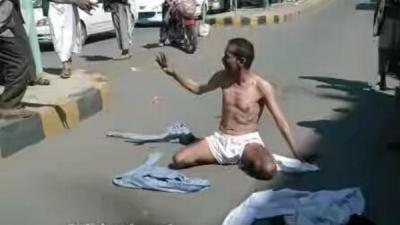 بالصوره .. جندي يمني يخلع ملابسه ويقطع أحد شوارع العاصمة صنعاء بعد أن أقدم الحوثيون على ضربه